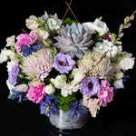 Elegant bouquet with pink, purple, and blue blooms, accented by succulents and seasonal greenery, showcasing Bloom by Anuschka’s fine flower crafting.