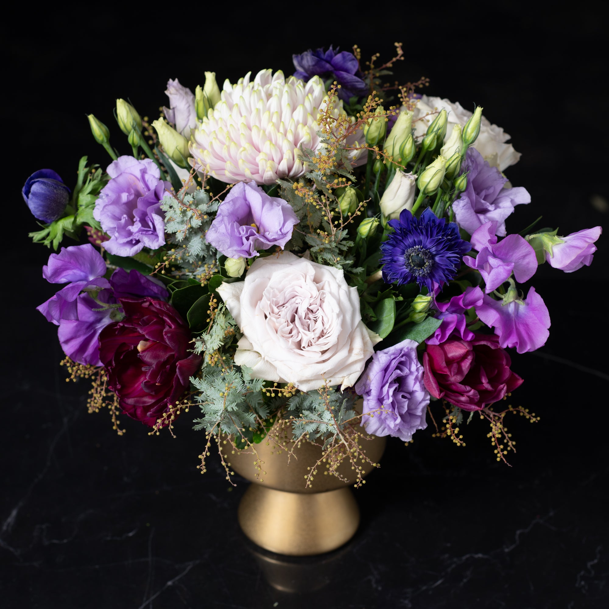 Elegant floral design featuring deep, rich hues in a metallic gold vase, reflecting the luxe quality of our premier Denver flower shop.