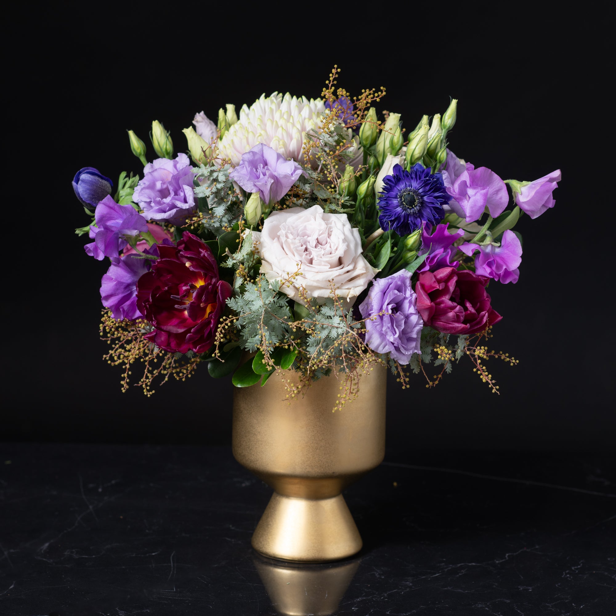 Lavish purple, burgundy, and lavender flowers in a gold pedestal vase, showcasing Bloom by Anuschka’s upscale Cherry Creek florist artistry.