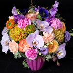 A stunning mixed flower arrangement in a striking pink vase featuring lisianthus daisies and orchids expertly crafted by Bloom by Anuschka a premier Denver flower shop