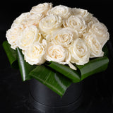 Close-up of velvety white roses in a modern hatbox, showcasing Bloom by Anuschka’s expert flower craft.