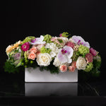 Arrangement of pink orchids, peach roses, and soft hydrangeas by Bloom by Anuschka, showcasing the artistry of flower crafting.