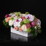 Arrangement of pink orchids, peach roses, and soft hydrangeas by Bloom by Anuschka, showcasing the artistry of flower crafting.