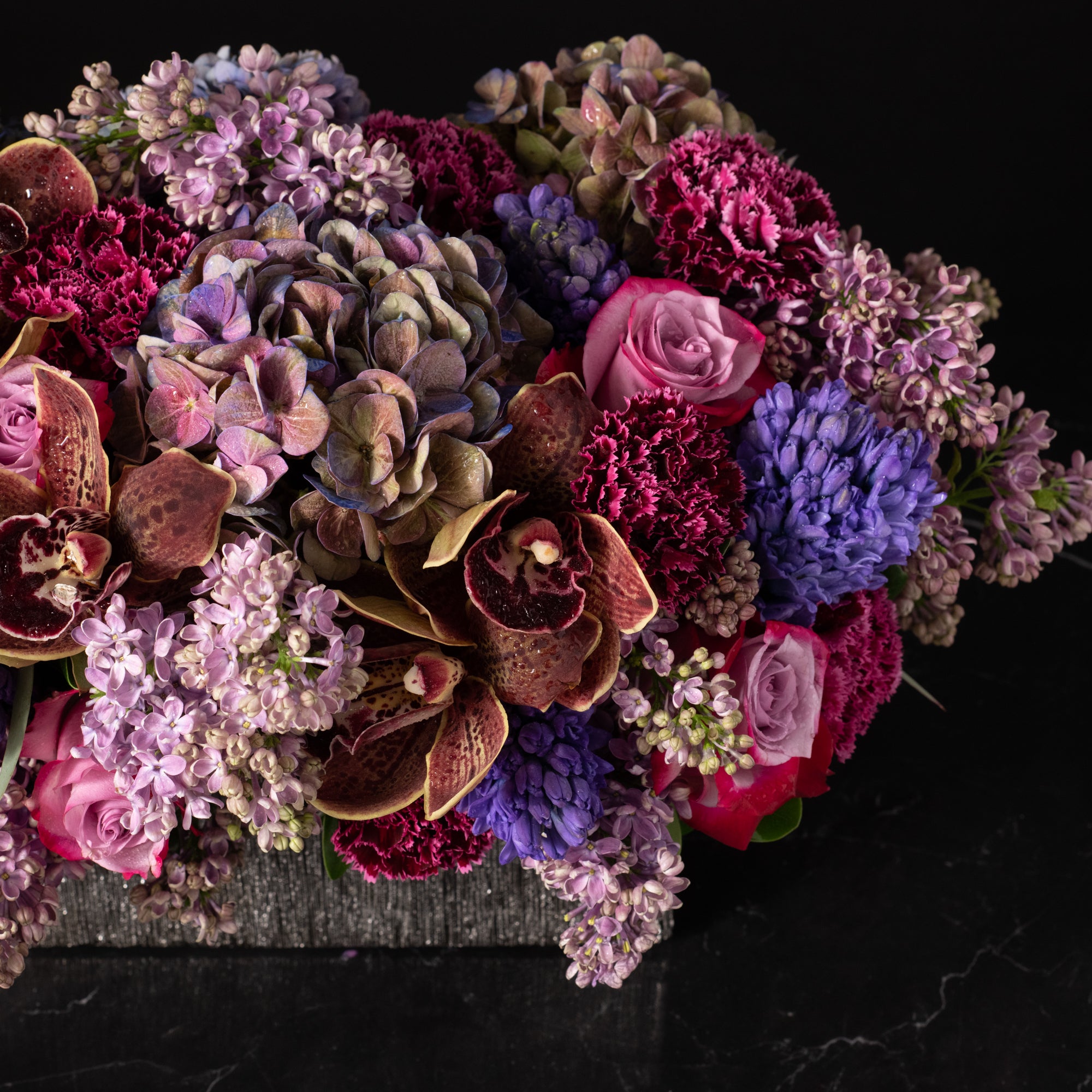 Deep-toned floral arrangement with orchids, hydrangeas, and roses, showcasing Bloom by Anuschka’s expertise in elegant flower crafting.